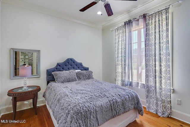 bedroom featuring ceiling fan, hardwood / wood-style flooring, and ornamental molding