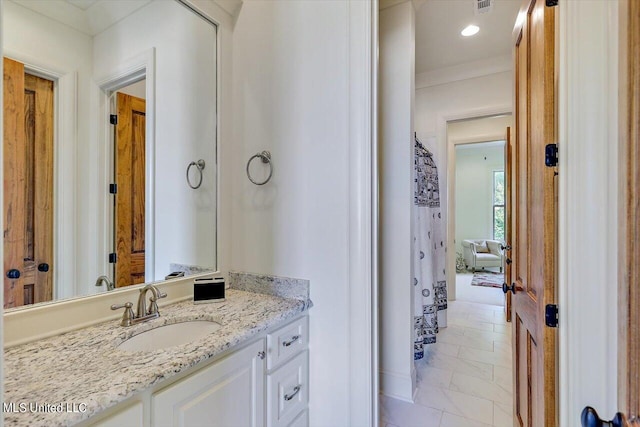 bathroom featuring vanity, crown molding, and tile patterned flooring