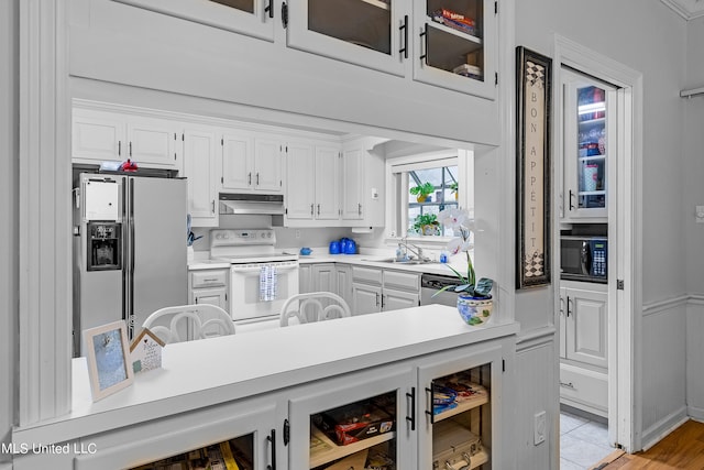 kitchen featuring white cabinetry, sink, light wood-type flooring, and white appliances