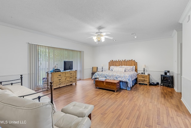 bedroom with crown molding, a textured ceiling, wood-type flooring, and ceiling fan