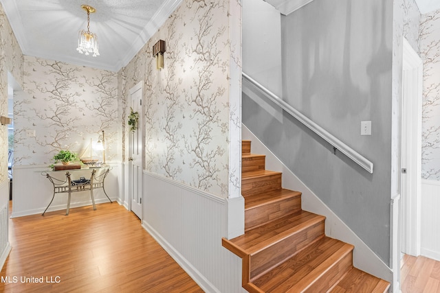 stairs featuring ornamental molding and hardwood / wood-style flooring