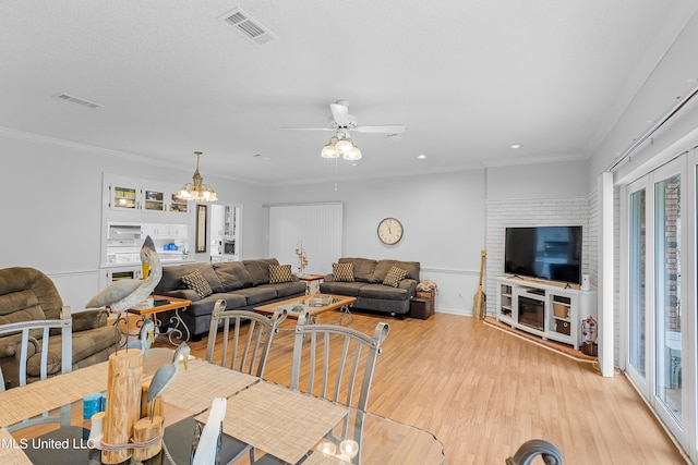 living room featuring crown molding, ceiling fan with notable chandelier, and light hardwood / wood-style floors