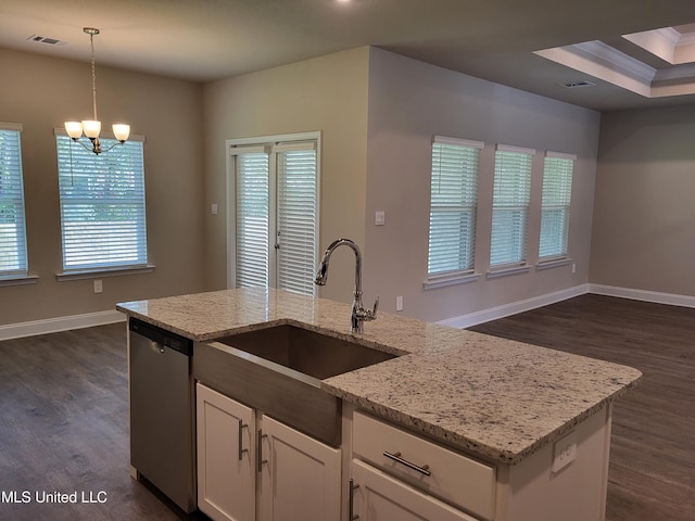 kitchen featuring light stone counters, stainless steel dishwasher, sink, pendant lighting, and white cabinetry