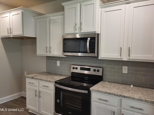 kitchen featuring white cabinets, backsplash, light stone counters, and range with electric cooktop