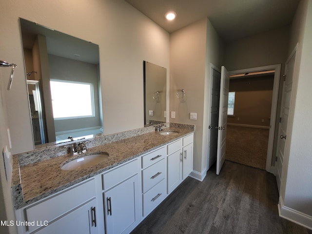 bathroom with a washtub, vanity, and hardwood / wood-style flooring