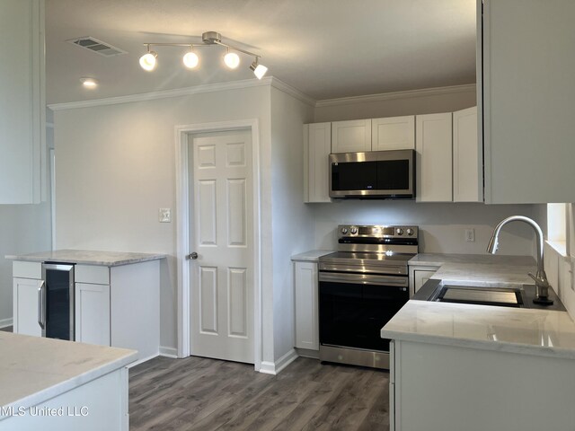 kitchen with white cabinetry, sink, beverage cooler, appliances with stainless steel finishes, and ornamental molding