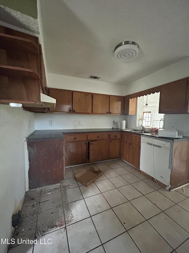 kitchen featuring visible vents, brown cabinets, a sink, a textured ceiling, and dishwasher