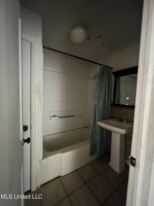 full bath with tile patterned floors, shower / bath combo, and a sink