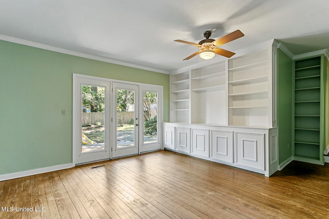 interior space with ornamental molding, hardwood / wood-style floors, built in shelves, and ceiling fan