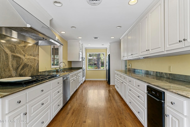 kitchen with range hood, white cabinetry, sink, dark stone countertops, and black appliances