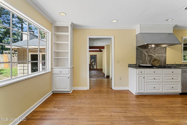 kitchen featuring backsplash, white cabinets, plenty of natural light, and light wood-type flooring