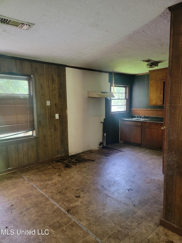 kitchen with a textured ceiling and wood walls