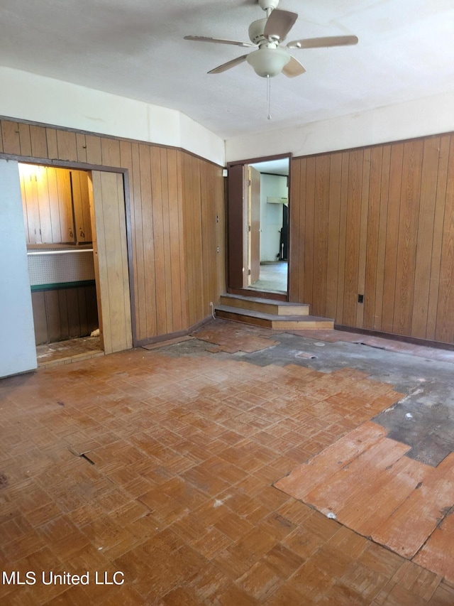 unfurnished room with wooden walls and ceiling fan