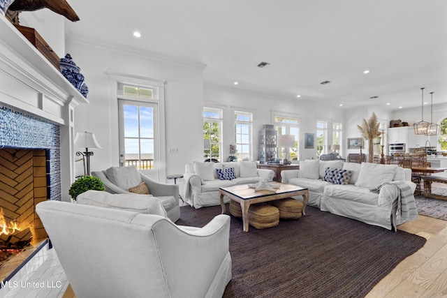 1221 E Beach Blvd, Pass Christian, MS 39571 - living room with a warm lit fireplace, healthy amount of natural light, recessed lighting, crown molding, and light wood finished floors