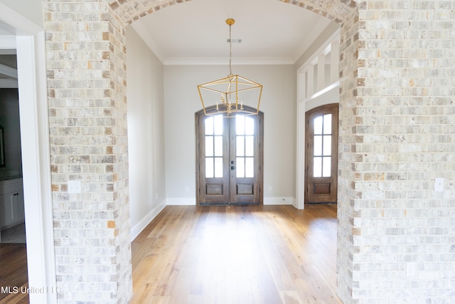 foyer entrance featuring french doors, light hardwood / wood-style floors, and ornamental molding