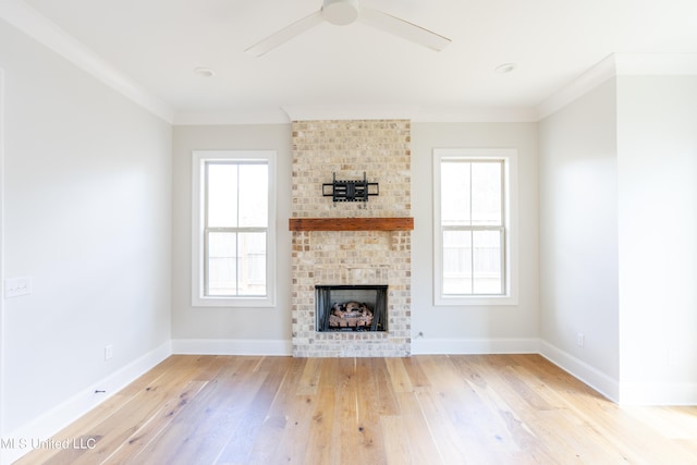 unfurnished living room featuring crown molding, light hardwood / wood-style flooring, a fireplace, and ceiling fan