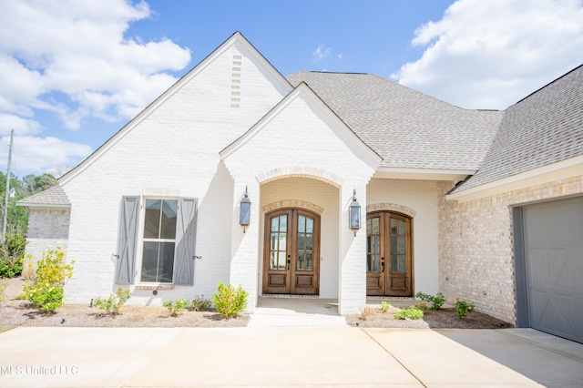 view of exterior entry with french doors and a garage