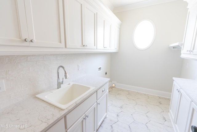 clothes washing area with electric dryer hookup, hookup for a washing machine, sink, crown molding, and cabinets