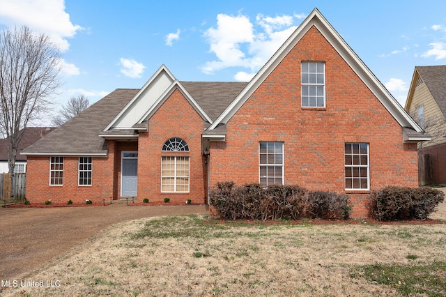 traditional-style house featuring brick siding and a front lawn