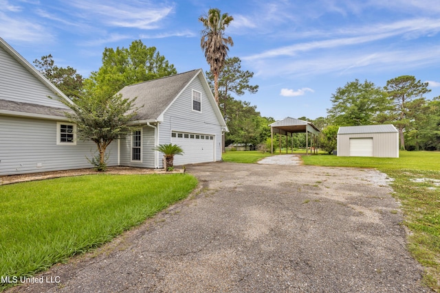 16609 Old River Rd, Vancleave, MS 39565 - view of front of property featuring a garage, a front lawn, asphalt driveway, an outbuilding, and a shingled roof
