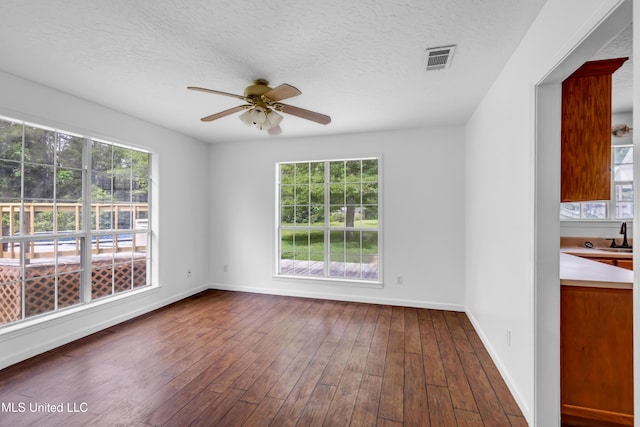 16609 Old River Rd, Vancleave, MS 39565 - unfurnished room featuring a ceiling fan, plenty of natural light, dark wood-type flooring, baseboards, and a textured ceiling
