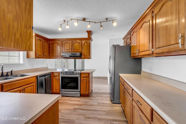 16609 Old River Rd, Vancleave, MS 39565 - kitchen with stainless steel appliances, under cabinet range hood, a sink, brown cabinetry, and a peninsula
