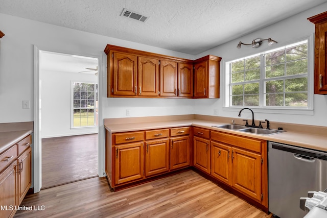 16609 Old River Rd, Vancleave, MS 39565 - kitchen with stainless steel dishwasher, a sink, light wood finished floors, plenty of natural light, and a textured ceiling