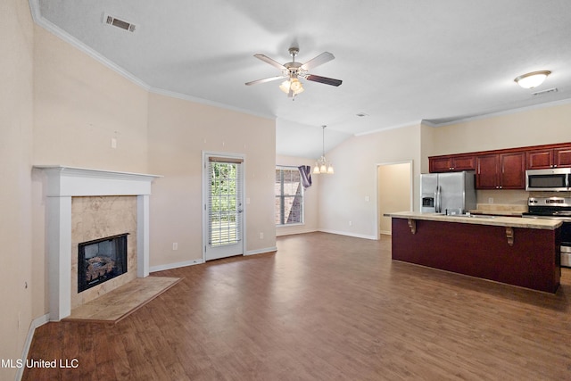 217 Belle Chasse Cir, Jackson, MS 39272 - kitchen featuring stainless steel appliances, a breakfast bar area, light countertops, dark wood-style floors, and a tiled fireplace