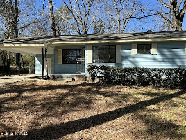 view of front of property featuring an attached carport and dirt driveway