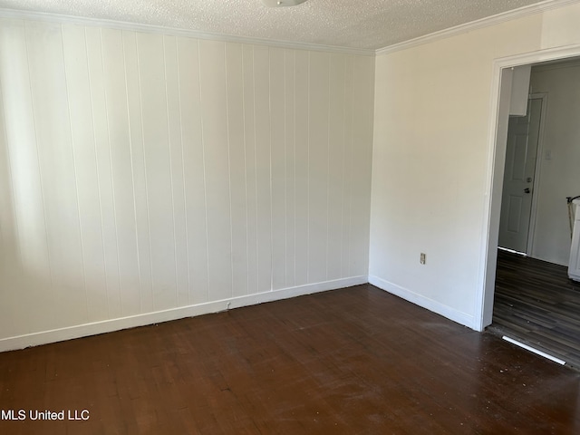 spare room with baseboards, a textured ceiling, dark wood-style flooring, and crown molding