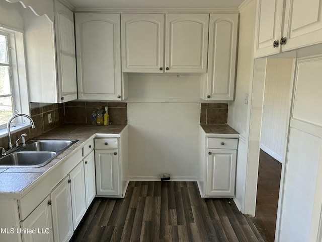 kitchen with a sink, dark wood finished floors, and white cabinets