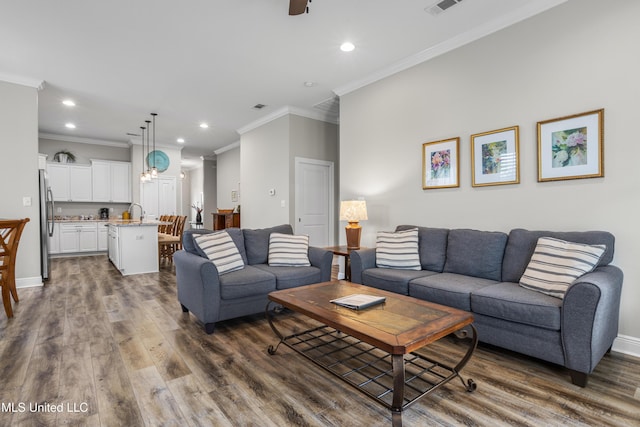 living room featuring dark hardwood / wood-style flooring, ceiling fan, and ornamental molding