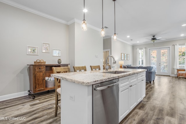 kitchen with french doors, white cabinets, a breakfast bar, dishwasher, and an island with sink