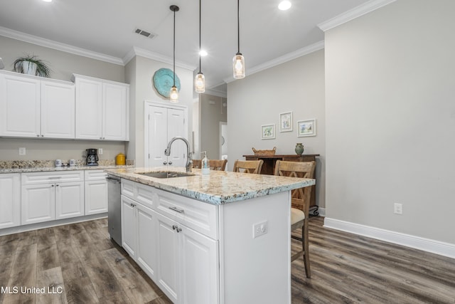 kitchen featuring white cabinets, sink, a kitchen island with sink, and a breakfast bar area