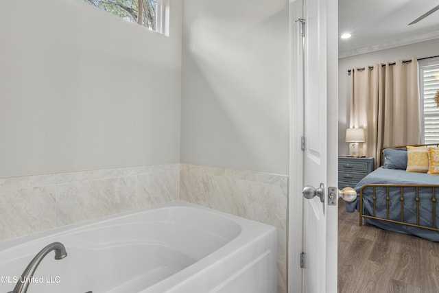 bathroom with a washtub, a healthy amount of sunlight, and wood-type flooring