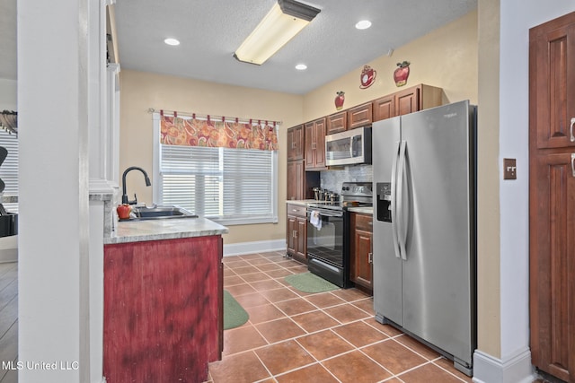 kitchen featuring dark tile patterned flooring, sink, appliances with stainless steel finishes, and tasteful backsplash