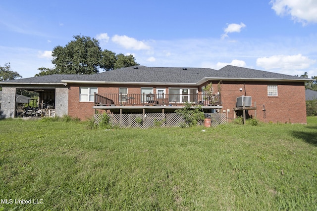 rear view of house with a lawn, a wooden deck, and central AC