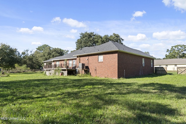 rear view of house featuring a deck and a lawn