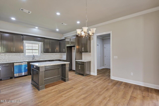 kitchen featuring stainless steel dishwasher, a kitchen island, light hardwood / wood-style flooring, and pendant lighting