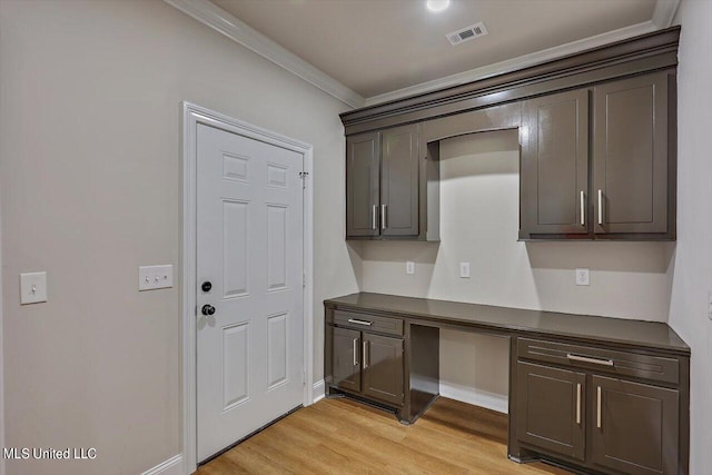 kitchen with dark brown cabinets, ornamental molding, and light wood-type flooring