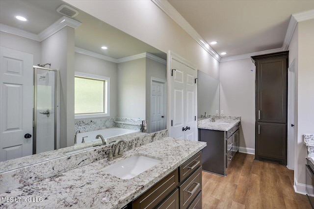 bathroom with vanity, crown molding, hardwood / wood-style flooring, and plus walk in shower