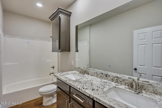 full bathroom with toilet, hardwood / wood-style floors, vanity, and bathing tub / shower combination