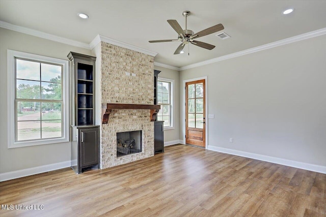 unfurnished living room featuring crown molding, light wood-type flooring, a fireplace, and ceiling fan