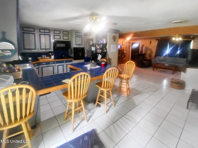 305 Bazinsky Rd, Vicksburg, MS 39180 - kitchen featuring black appliances, a ceiling fan, tile patterned flooring, tile counters, and open floor plan