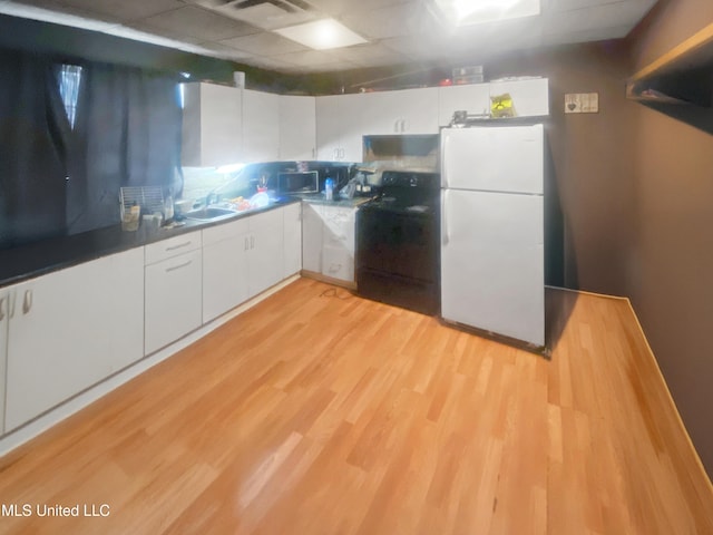 305 Bazinsky Rd, Vicksburg, MS 39180 - kitchen featuring freestanding refrigerator, stove, white cabinets, a sink, and light wood-style flooring