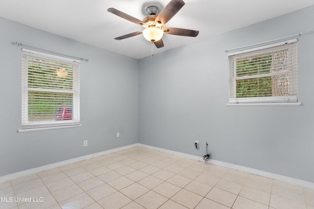 spare room with ceiling fan and light tile patterned flooring