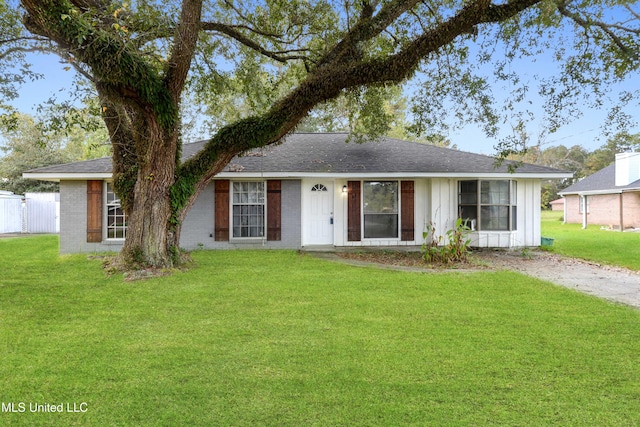 ranch-style house with a shingled roof, a front lawn, board and batten siding, and brick siding