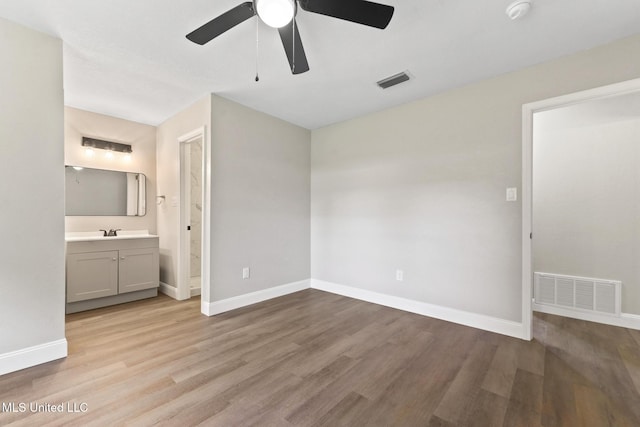 2518 El Viernes St, Gautier, MS 39553 - unfurnished bedroom with wood finished floors, connected bathroom, and a ceiling fan