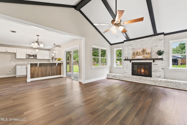 2518 El Viernes St, Gautier, MS 39553 - unfurnished living room featuring a chandelier, ceiling fan, beamed ceiling, a brick fireplace, and dark wood-type flooring
