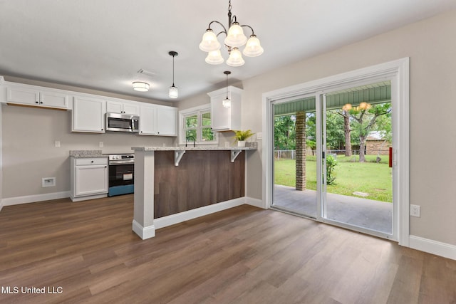 2518 El Viernes St, Gautier, MS 39553 - kitchen with appliances with stainless steel finishes, white cabinets, dark wood-style flooring, a chandelier, and a peninsula